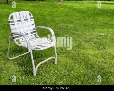 Faltbarer Rasensessel im Retro-Look auf grünem Gras Stockfoto