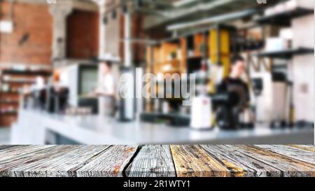 Einfacher Holztisch für Ausstellungsstücke mit verschwommenem Blick auf das Café. Stockfoto