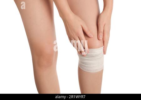 Frau mit Knie in medizinischem Verband auf weißem Hintergrund, Nahaufnahme Stockfoto