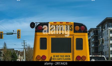 Schulbus auf der Straße am Morgen. Der Schulbus fährt auf der Vorstadtstraße Vancouver, Kanada - 28,2023. April. Straßenfoto, Kopierraum für t Stockfoto