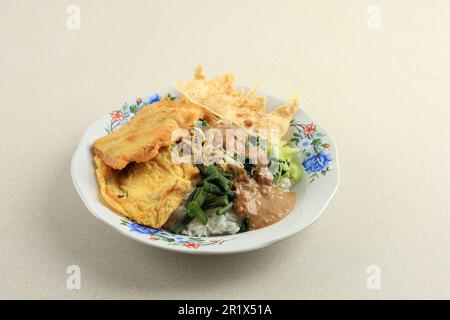 Sego Pecel, Reis mit gedämpfter, vegatabler und würziger Erdnusssoße. Indonesisches traditionelles javanesisches Tagesmenü zum Frühstück, Mittag- oder Abendessen. Popul Stockfoto
