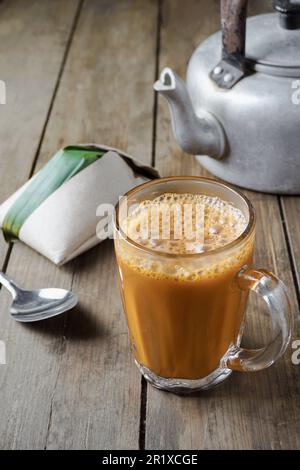 Ein beliebtes Frühstück in Malaysia ist ein heißes Getränk, Tee mit malaiischer Milch, genannt Teh Tarik, zum Essen mit Nasi Lemak Bungkus Stockfoto