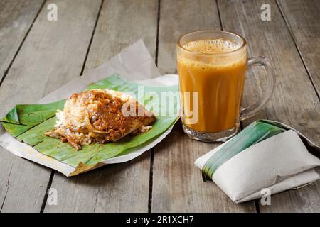 Heißes Getränk Teh Tarik mit Kokosnussreis Nasi Lemak Bungkus ist ein beliebtes Frühstück in Malaysia Stockfoto