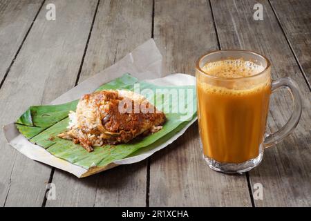 Heißes Getränk Teh Tarik mit Kokosnussreis Nasi Lemak Bungkus ist ein beliebtes Frühstück in Malaysia Stockfoto