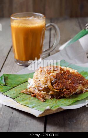 Asiatische Küche Kokosreis Nasi Lemak Bungkus und heißes Getränk Teh Tarik ist ein beliebtes Frühstück in Malaysia Stockfoto