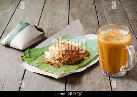 Heißes Getränk Teh Tarik mit Kokosnussreis Nasi Lemak Bungkus ist ein beliebtes Frühstück in Malaysia Stockfoto