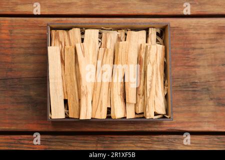 Palo Santo klebt im Karton auf einem Holztisch, Draufsicht Stockfoto