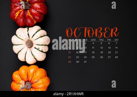 Oktober 2023 Kalender und Kürbisse auf schwarzem Hintergrund. Stockfoto