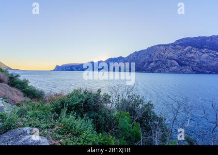 Blick auf den Sonnenuntergang am Nordufer des Gardasees, an einem klaren Wintertag, in Nago–Torbole, Trentino, Norditalien Stockfoto