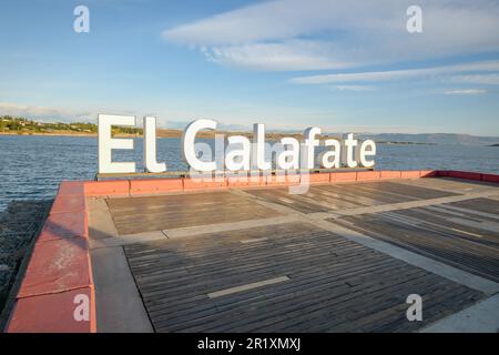 Ein Schild mit der Aufschrift „El Calafate“, das auf einem Zaun in der Nähe eines Hafengebiets angebracht ist Stockfoto