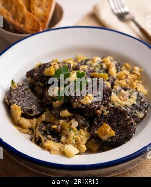 Rührei, junger Knoblauch und Schwarzblutwurst. Traditionelles spanisches Tapa-Rezept. Stockfoto