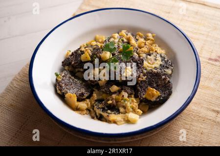 Rührei, junger Knoblauch und Schwarzblutwurst. Traditionelles spanisches Tapa-Rezept. Stockfoto