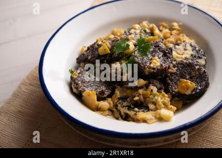 Rührei, junger Knoblauch und Schwarzblutwurst. Traditionelles spanisches Tapa-Rezept. Stockfoto