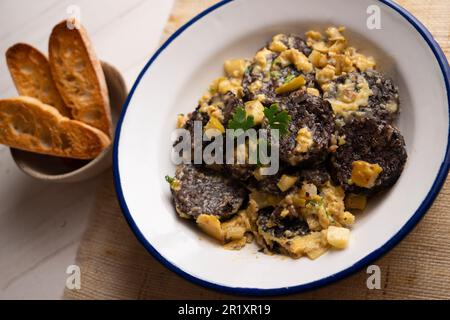 Rührei, junger Knoblauch und Schwarzblutwurst. Traditionelles spanisches Tapa-Rezept. Stockfoto