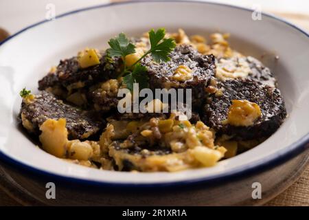 Rührei, junger Knoblauch und Schwarzblutwurst. Traditionelles spanisches Tapa-Rezept. Stockfoto