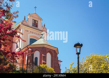 Katholische Kirche St. Anna in Warschau. Blick von der Ostseite, blühendes Flieder im Hintergrund Stockfoto