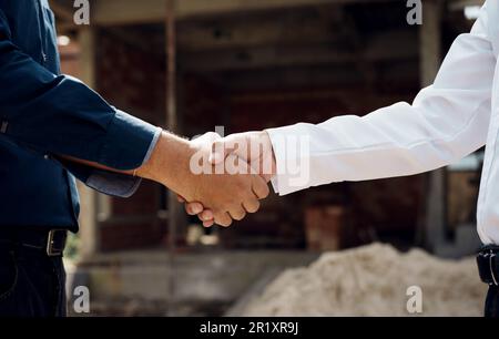 Ingenieure schütteln sich auf der Baustelle die Hände. Stockfoto