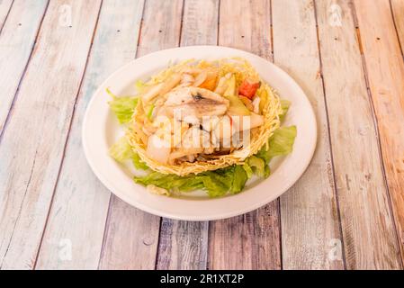 Ein chinesischer Fischkorb auf einem Salatbett Stockfoto