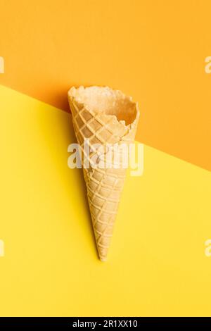 Waferkonus leeren. Süßes Eiskornet auf farbenfrohem Hintergrund. Draufsicht. Stockfoto