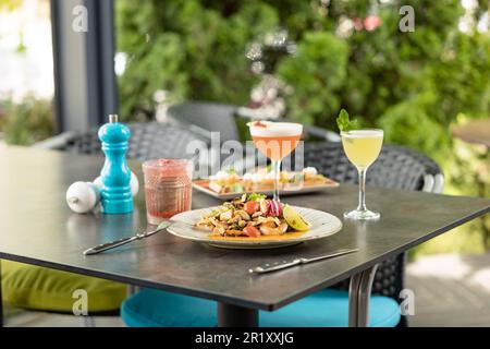 Salat mit Muscheln und Meeresfrüchten mit einem Cocktail im Restaurant. Gourmetessen Stockfoto