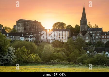 Dienstag, 16. Mai 2023. Malmesbury, Wiltshire, England – der klare Himmel über Nacht sorgt für einen farbenfrohen, aber kalten Start in den Tag, wenn die Sonne hinter der historischen Abtei in der hügeligen Stadt Malmesbury in Wiltshire aufgeht. Kredit: Terry Mathews/Alamy Live News Stockfoto