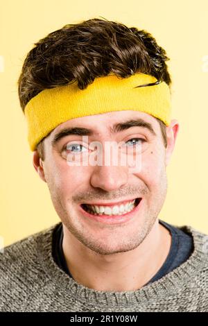 Hat jemand Käse gesagt? Ein gutaussehender junger Mann, der allein im Studio steht und posiert, während er ein Stirnband trägt. Stockfoto