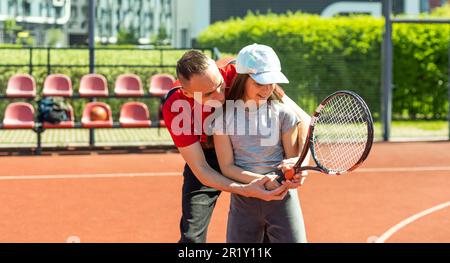 Aktive Familie spielt Tennis auf dem Platz Stockfoto