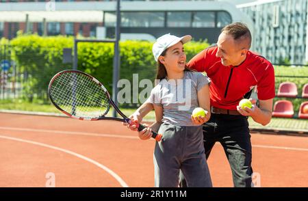 Aktive Familie spielt Tennis auf dem Platz Stockfoto