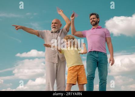 Vatertag. Kind hat Spaß mit Spielzeug Papier Flugzeug. Männer Generation Familie mit drei verschiedenen Generationen Alter Großvater Vater und Sohn. Wochenende Stockfoto