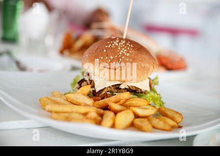 Großer leckerer Burger mit pommes frites Stockfoto