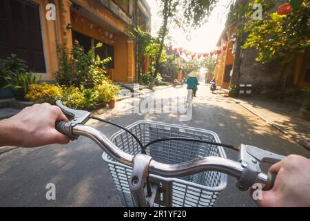 POV Fahrradfahren von Touristen in der alten Stadt Hoi an in Vietnam. Selektiver Fokus auf Handgriff. Stockfoto