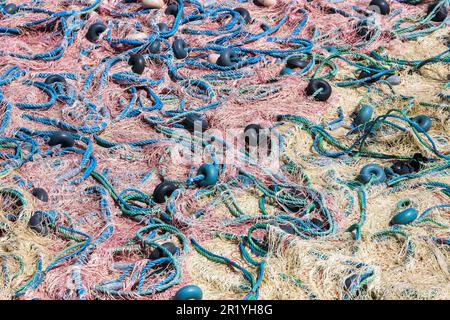 Mischung aus bunten Fischernetzen, Schwimmern und Seilen. Hintergrund des Fischers. Stockfoto