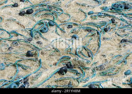 Mischung aus bunten Fischernetzen, Schwimmern und Seilen. Hintergrund des Fischers. Stockfoto