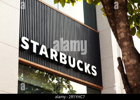 Ho-Chi-Minh-Stadt, Vietnam - 7. April 2023: Kommerzielles Schild auf einem berühmten Café mit Starbucks-Logo. Werbung für beliebte Kaffeehausmarken auf einem B Stockfoto