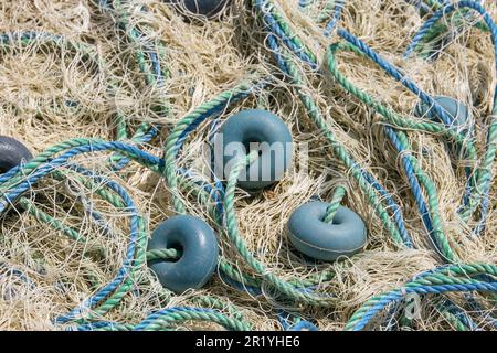 Mischung aus bunten Fischernetzen, Schwimmern und Seilen. Hintergrund des Fischers. Stockfoto