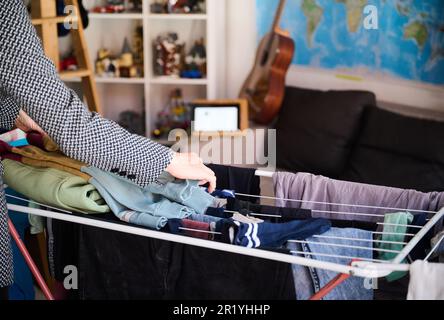 Berlin, Deutschland. 05. Mai 2023. Eine Mutter nimmt an einer Videokonferenz Teil, während sie die Wäsche im Zimmer ihres Kindes zusammenfaltet. Kredit: Annette Riedl/dpa/Alamy Live News Stockfoto