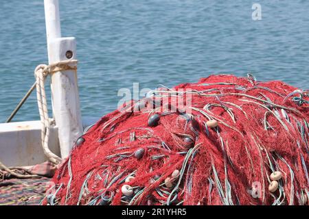 Mischung aus bunten Fischernetzen, Schwimmern und Seilen mit isoliertem Hintergrund von Schleppnetzbooten. Hintergrund des Fischers. Offener Raum. Stockfoto