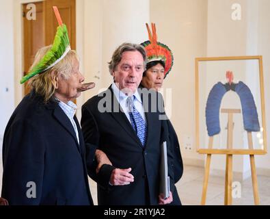 Berlin, Deutschland. 16. Mai 2023. Jean-Pierre Dutilleux (Zentrum), Aktivist, Autor und Mitbegründer der Regenwaldorganisation AFV, führt den Stammesführer Raoni Metuktire (l), ein Vertreter der Anliegen der indigenen Völker im Amazonas und des Regenwaldschutzes, nach Bellevue Palace. Der Bundespräsident lädt Chief Metuktire zu einem Gespräch ein. Kredit: Annette Riedl/dpa/Alamy Live News Stockfoto