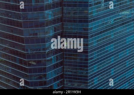 Aus nächster Nähe ein modernes Gebäude des Marina Bay Financial Centre, in dem der mittlere Teil des Büros tagsüber beleuchtet ist. Singapur Stockfoto