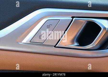 Verriegeln Sie die Entriegelungstaste in der Fahrzeugtür. Selektiver Fokus. Stockfoto