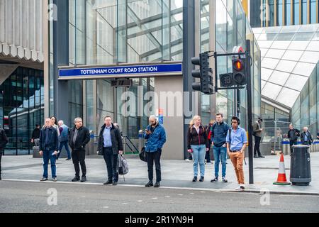 An einer Fußgängerüberquerung vor der Londoner U-Bahn-Station Tottenham Court Road stehen Leute und warten. Stockfoto