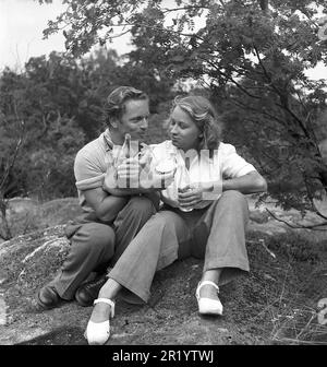 Ein paar auf einem Picknick. Ein junges Paar hat an diesem Sommertag Sandwiches und Limonade mitgebracht. Schweden 1944. Kristoffersson Ref. M19-3 Stockfoto