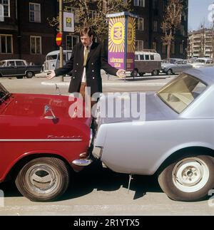 Fahren in der 1960er. Ein Mann steht bei zwei Autos, die entweder viel zu nah beieinander geparkt oder miteinander kollidiert sind. Der rote Opel Kadett steht so, dass die Stoßstange zum anderen Auto zeigt. Was der Mann mit seinem Gesichtsausdruck meint, ist schwer zu interpretieren, aber höchstwahrscheinlich besitzt er eines der Autos und ist natürlich nicht zufrieden mit dem, was er sieht. Schweden 1969 Kristoffersson Stockfoto