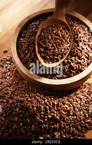Schüssel mit braunen Leinsamen auf einem Holztisch Stockfoto