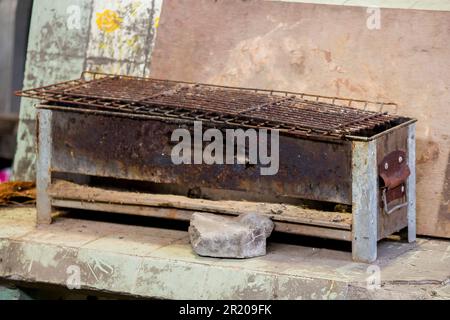 Der alte Grill ist rostig und liegt auf dem Boden. Stockfoto