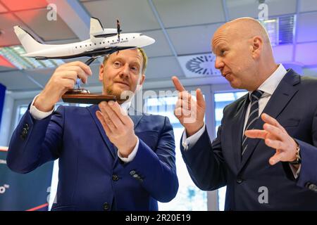 16. Mai 2023, Sachsen, Schkeuditz: Michael Kretschmer (l, CDU), sächsischer Premierminister, betrachtet nach der bahnbrechenden Zeremonie für die Produktionslinie des neuen D328 Eco Turboprop-Typs am Flughafen Leipzig/Halle mit Peter Gatz, Geschäftsführer von Private Wings, das Modell eines D328 Eco. Flugzeughersteller Deutsche Aircraft plant hier den Bau eines nachhaltigen Regionalflugzeugs mit dem neuen Turboprop-Typ. Nach Angaben des Herstellers ist der D328 Eco eine nachhaltigere Entwicklung des Dornier 328, der Anfang der 1990er Jahre gebaut wurde, und es wird erwartet, dass das Werk bis zu 350 neue Arbeitsplätze schafft. Das wird es Stockfoto