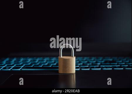 Goldenes Vorhängeschloss auf einem offenen schwarzen Laptop in einem konzeptionellen Bild von Online-Daten- und Passwortschutz. Stockfoto