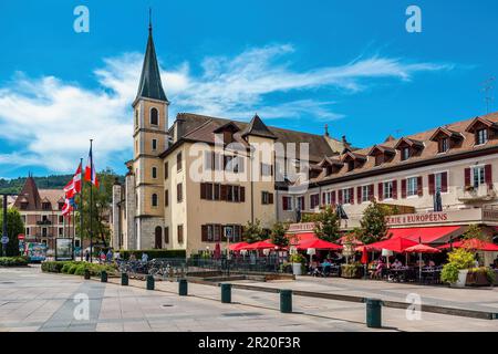 Restaurant im Freien, alte Häuser und katholische Kirchenglocke unter blauem Himmel im alten historischen Zentrum von Annecy, Frankreich. Stockfoto