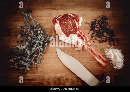 Wagyu Tomahawk Steak auf einem Holzbrett mit Salz und Pfeffer Stockfoto