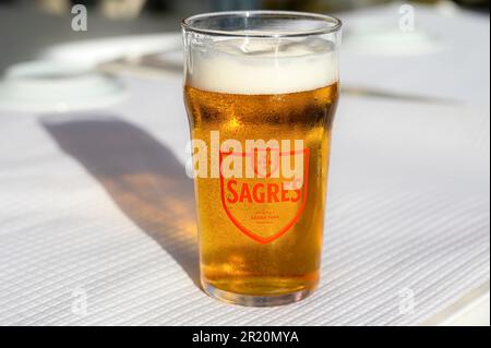 Lissabon, Portugal - 30. April 2023: Ein Bierglas mit der Marke Sagres auf einem Restauranttisch im Innenhof. Stockfoto